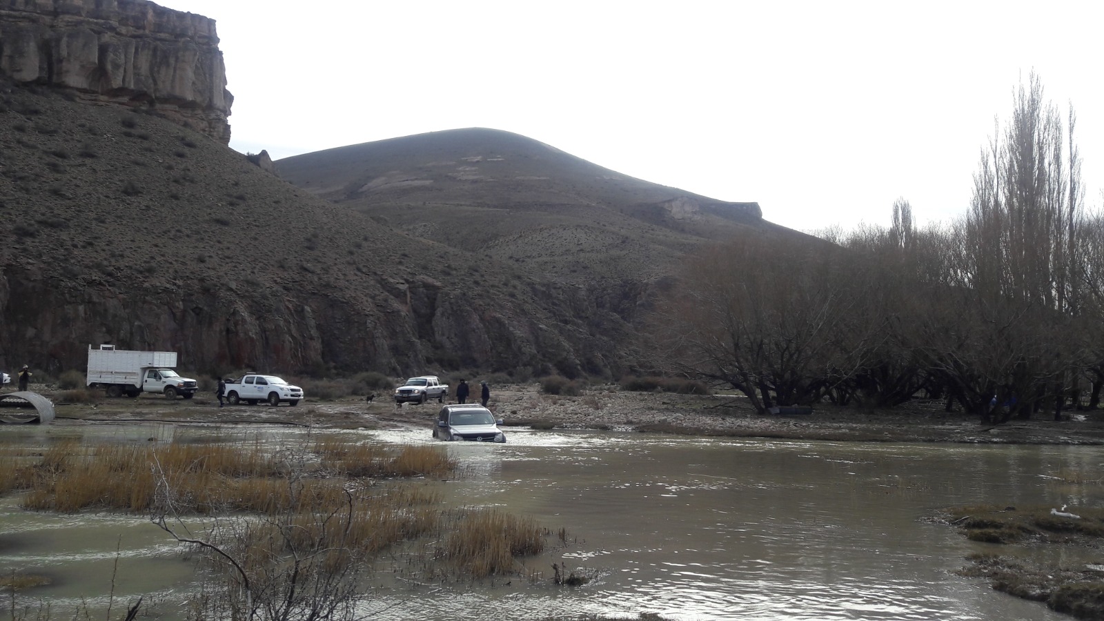 Vehículos 4x4 cruzando un río en zona de cañadones